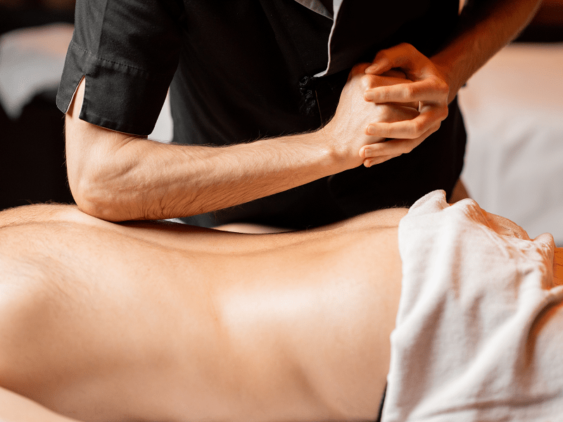 A man from Las Vegas getting a deep tissue massage at his home in Los Angeles after doing a deep tissue massage near me search