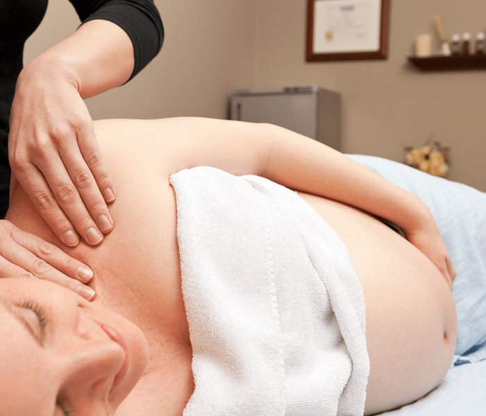 A woman getting a prenatal massage at home from Tranquil, a mobile massage company in Las Vegas and Los Angeles, after doing a prenatal massage near me search online
